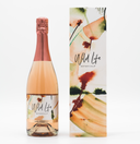 Wild Life Botanicals Blush 75 open bottle on table with full glass of fizz. Ultra-low alcohol, low calorie and low carb sparkling wine. Healthy wine alternative. Bespoke Wild Life box incorporating original artwork by Cornish artist.